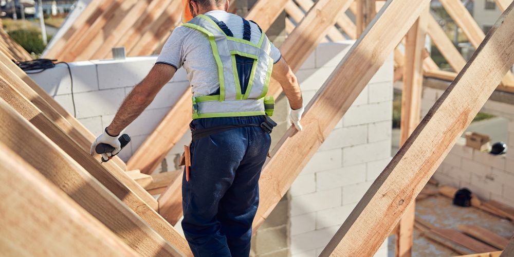 cautious-contractor-working-on-a-roof-of-a-constru-TPAUX9W